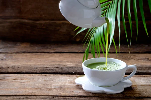 Налейте Зеленый Чай Чайника Белый Стакан Старом Деревянном Фоне — стоковое фото