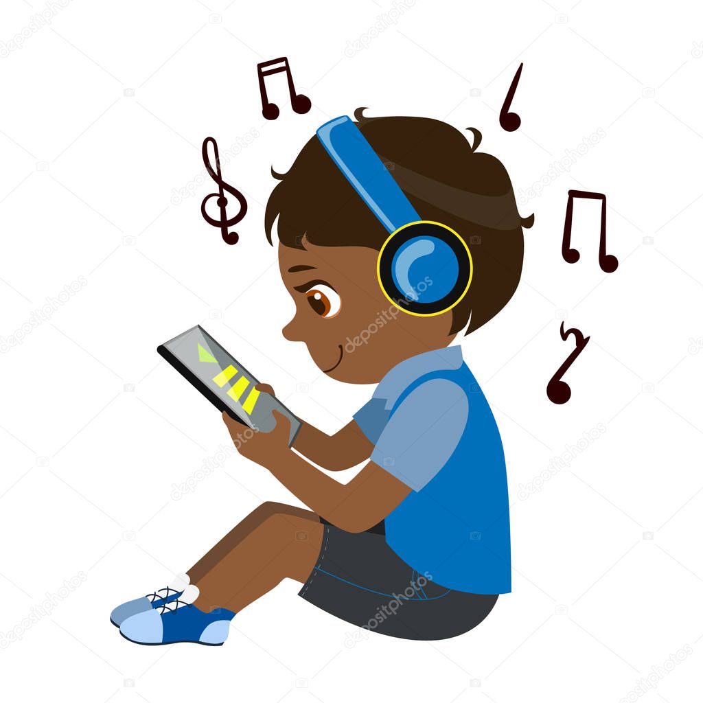Boy Reading Text From Tablet And Listening To Music Through Headphones