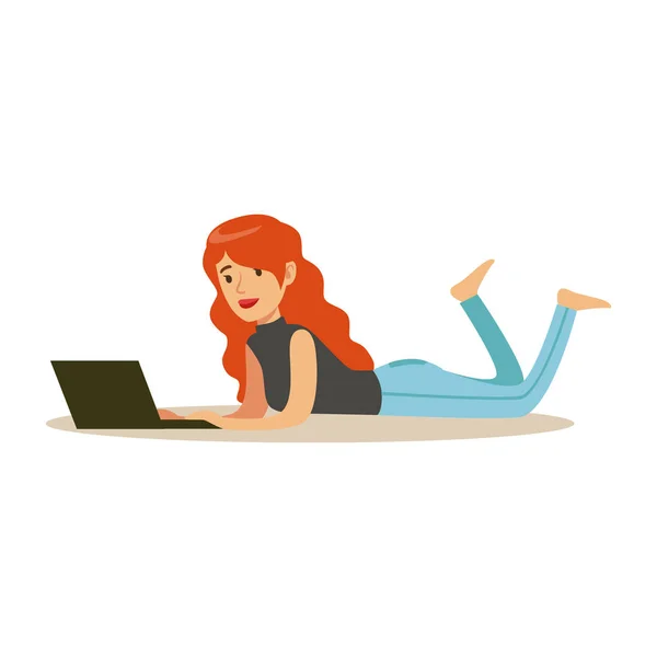 Mooie jonge roodharige vrouw ligt op haar buik terwijl het gebruiken van haar laptop, kleurrijke karakter vector illustratie — Stockvector