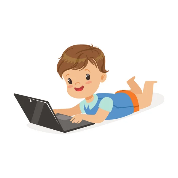 Šťastný chlapec leží na podlaze pomocí přenosného počítače pro přehrávání. Dítě a moderní technologie barevná kreslená postavička vektorové ilustrace — Stockový vektor