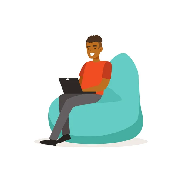 Sorrindo homem casual vestir, sentado na cadeira saco de feijão e trabalhando com laptop, coworking espaço vetor Ilustração — Vetor de Stock