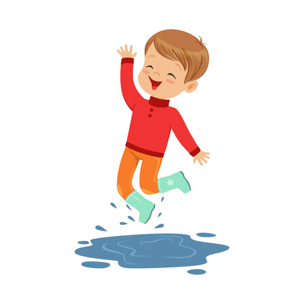 Милый маленький мальчик играет на луже

