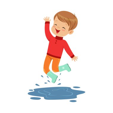 Su birikintisi üzerinde oynayan sevimli küçük çocuk