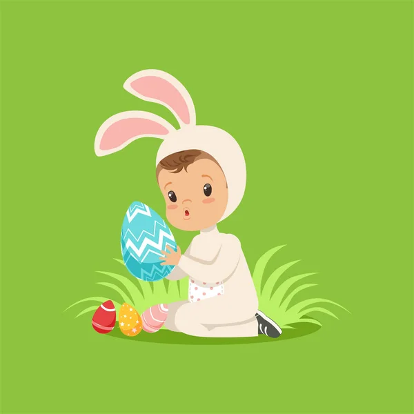 Dulce bebé en traje de conejito sentado en la hierba jugando con huevo pintado, niño divirtiéndose en el vector de la caza del huevo de Pascua Ilustración — Vector de stock