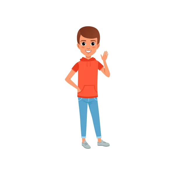 Mignon personnage de garçon dans des vêtements décontractés élégants t-shirt à capuche avec poche et jean. Enfant posant avec l'expression du visage souriant et agitant la main. Dessin animé vecteur plat — Image vectorielle