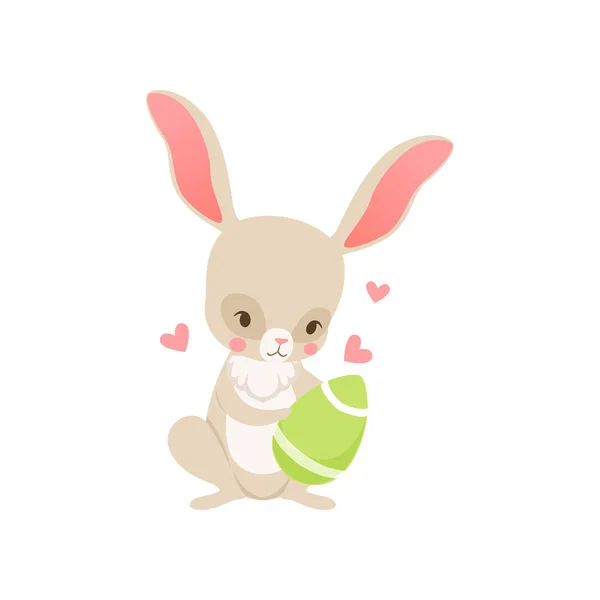 Lindo conejito de dibujos animados sosteniendo huevo verde, personaje divertido conejo, Feliz Pascua concepto de dibujos animados vector Ilustración — Archivo Imágenes Vectoriales