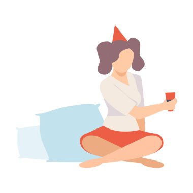 Genç ve güzel bir kadın pijama partisinde elinde bir bardak şarap vektörü resmiyle oturuyor.