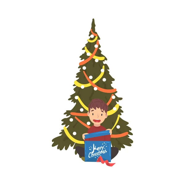 Ragazzo carino seduto accanto all'albero di Natale con scatola regalo, vigilia di Natale, illustrazione vettoriale della celebrazione di Capodanno — Vettoriale Stock