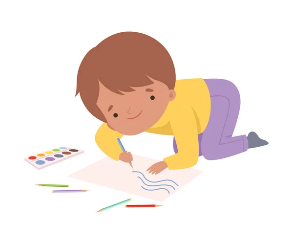 Милий хлопчик сидить на підлозі і малює картину з олівцями, чарівний молодий художник мультяшний персонаж, діти творче хобі Векторні ілюстрації — стоковий вектор