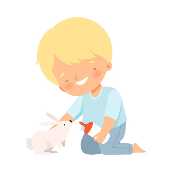 Petit garçon nourrissant son lapin pelucheux isolé sur fond blanc Illustration vectorielle — Image vectorielle