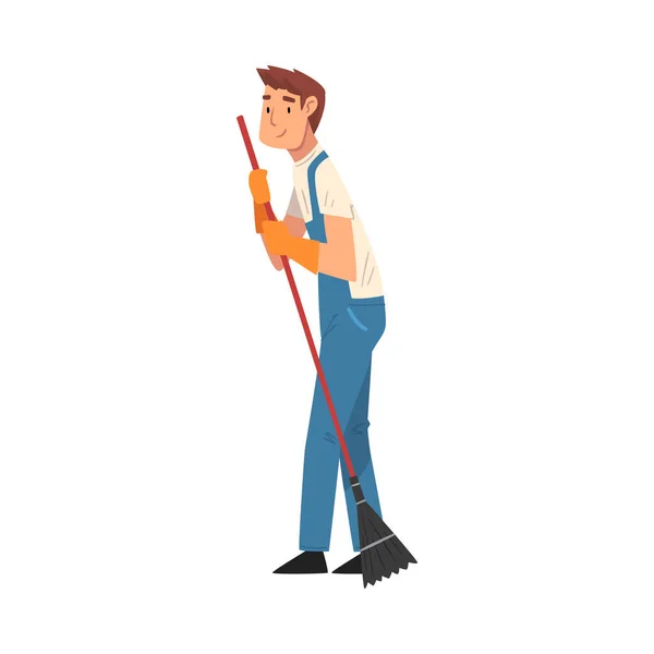 Profesjonalny sprzątacz zamiatający podłogę, męski bohater ubrany w niebieskie kombinezony i rękawiczki gumowe, personel firmy sprzątającej Ilustracja wektora — Wektor stockowy