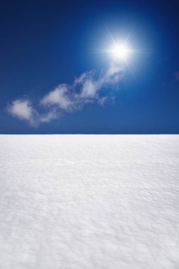Güneş ve mavi gökyüzü ile beyaz karlı tarla