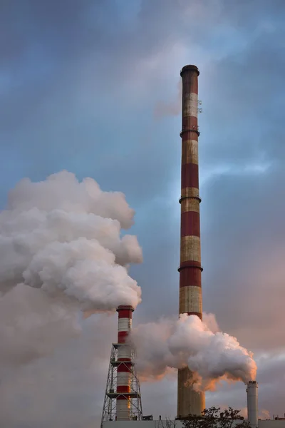 Günbatımında endüstriyel baca duman