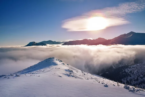 Salida del sol en las nubes cubiertas de picos de montaña Tatra — Foto de Stock