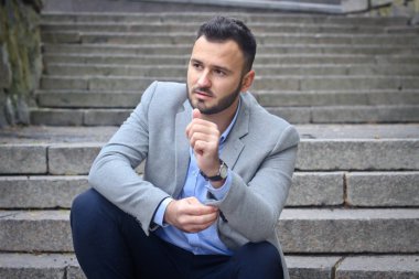 Eski bir Avrupa şatosunun büyük basamaklarında sakallı bir adamın portresi. Gelecekteki bir projeyi düşünen iş adamı. Şık elbiseli şık bir adam..