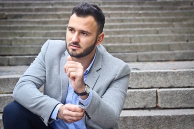 Eski bir Avrupa şatosunun büyük basamaklarında sakallı bir adamın portresi. Gelecekteki bir projeyi düşünen iş adamı. Şık elbiseli şık bir adam..