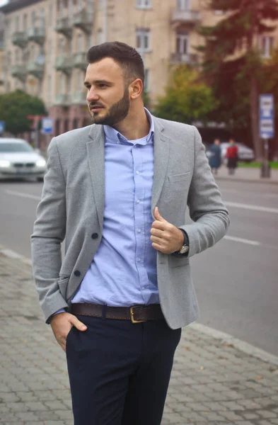 Porträt eines Geschäftsmannes auf der Straße in der Nähe einer europäischen Stadt. ein bärtiger, gutaussehender Mann, stilvoll gekleidet. modischer Typ Hipster. Aktienfotos — Stockfoto