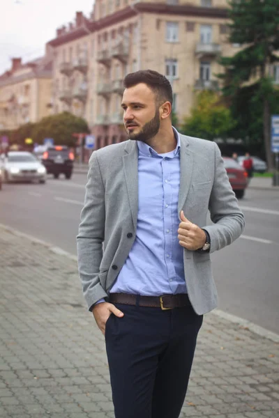 Porträt eines Geschäftsmannes auf der Straße in der Nähe einer europäischen Stadt. ein bärtiger, gutaussehender Mann, stilvoll gekleidet. modischer Typ Hipster. Aktienfotos — Stockfoto
