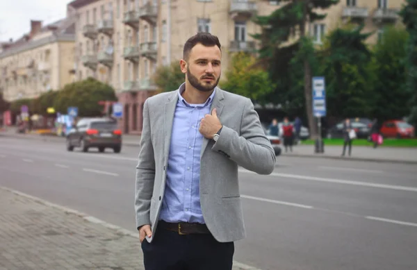 Porträt eines Geschäftsmannes auf der Straße in der Nähe einer europäischen Stadt. ein bärtiger, gutaussehender Mann, stilvoll gekleidet. modischer Typ Hipster. Aktienfotos — Stockfoto