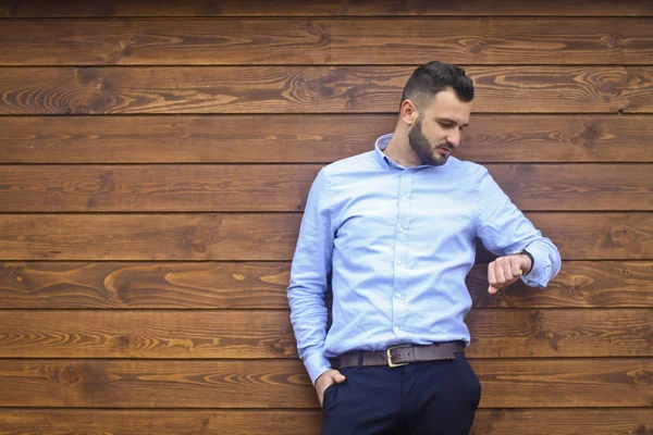 Retrato de un hombre guapo con una camisa sobre un fondo de pared de madera. Empresario, jefe con ropa elegante. Foto de stock para el diseño —  Fotos de Stock