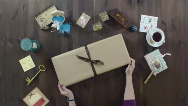 Розпакування подарункової коробки на столі — стокове відео