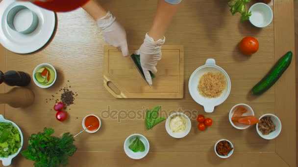 Vista superior de la hembra cortada a mano pepino, tomate, pescado, orégano, salsa, queso — Vídeos de Stock