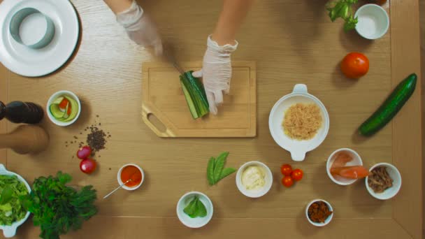 Tampilan atas tangan perempuan memotong mentimun, tomat, ikan, oregano, saus, keju — Stok Video