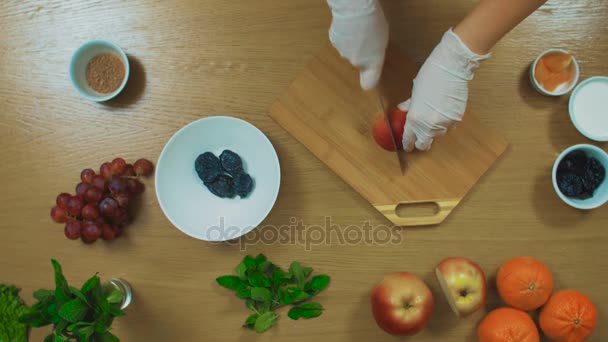 Felülnézet nő gyártás egy gyümölcssaláta — Stock videók