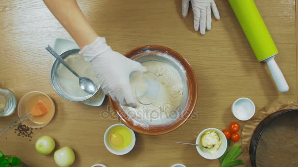 Woman make dough for dumplings cookies in glass bowl, top view — Stock Video