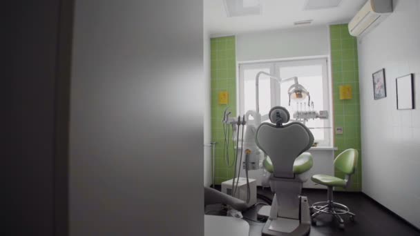 Кімната з стоматологічним зеленим стільцем та медичним обладнанням — стокове відео