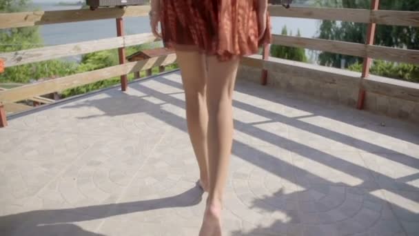 Schönes junges Mädchen bewegt sich auf dem Balkon — Stockvideo