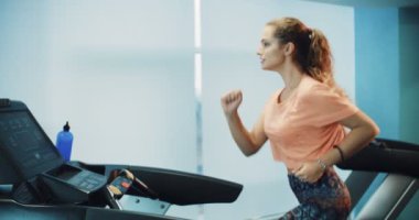 Spor salonunda treadmill çalıştıran çekici kıvırcık kız