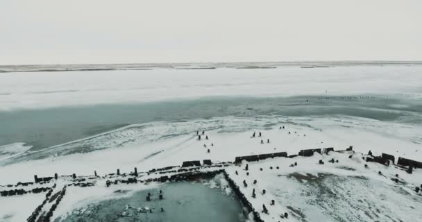 Volando sobre el lago. Lago congelado cubierto con una gruesa capa de hielo y nieve — Vídeo de stock