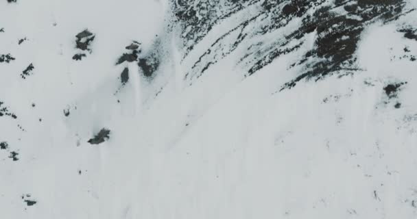 A sobrevoar o lago. Lago congelado coberto com uma espessa camada de gelo e neve. Vestígios de animais — Vídeo de Stock