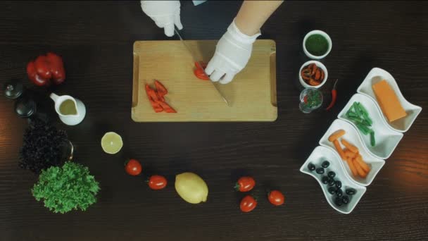 Bovenaanzicht snijden peper aan boord met chef-kok handen — Stockvideo