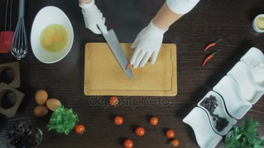 Üstten Görünüm. Kesme tahtası üzerinde bir havuç kırmızı biber ile doğrama Şef. Çekirdekleri çıkarın