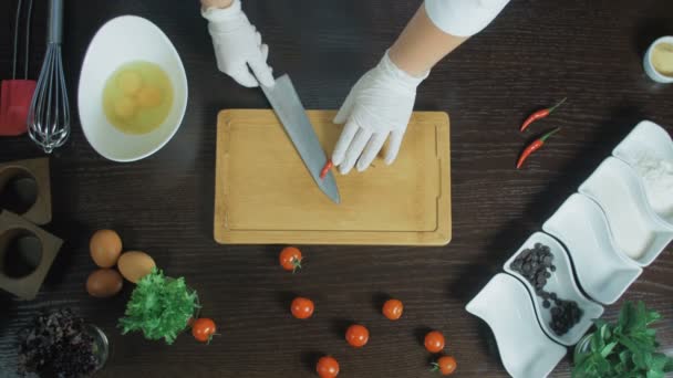 Vista superior. Chef picando una zanahoria con pimiento rojo en la tabla de cortar. Retire las semillas — Vídeos de Stock