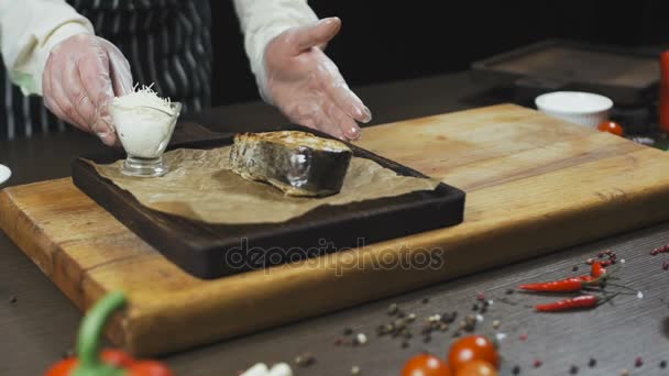 Рыба приготовленная и подаваемая с соусом и солью на деревянной доске — стоковое видео