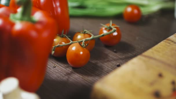 Слайд-шот томатов и перца на деревянном столе — стоковое видео