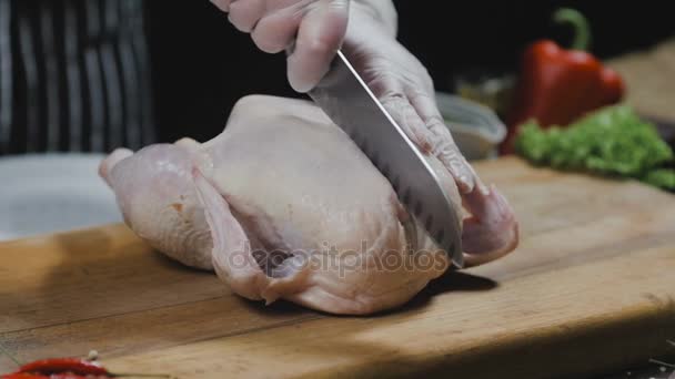 El chef está cortando el pollo en una tabla de madera — Vídeos de Stock