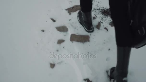 Chodzenie w czarne spodnie i buty czarny rock. Snow ziemią — Wideo stockowe