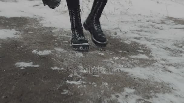 Siyah pantolon ve siyah kaya ayakkabı yürüyüş. kar yere — Stok video