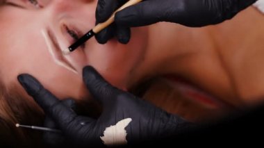 Slayt görünümünde. Siyah eldiven boya kaşları kalıcı makyaj profesyonel uzman.