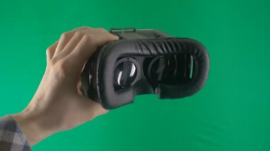 Adamın ellerini almak Vr gözlük onları vasıl Geen geçmiş. Sanal gerçeklik maskesi ile yeşil perde.