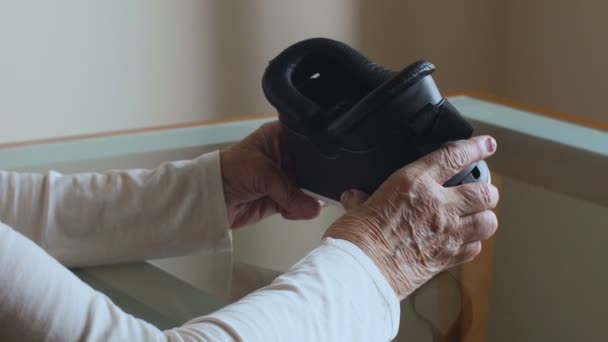 Mujer mayor sostiene gafas VR. Mujer de manos muy viejas . — Vídeo de stock