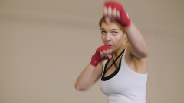 Fiatal nő boksz, kezében piros boksz szalagok csomagolva. Gyönyörű női ökölvívó képzés az edzőteremben. — Stock videók