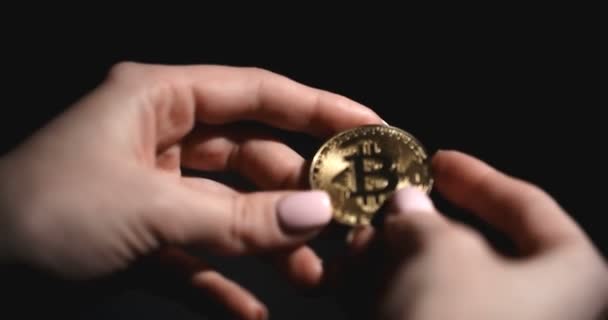 Žena držící Bitcoin mince v rukou. Tma na pozadí — Stock video