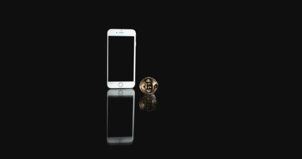 Horizont 的比特币硬币和智能手机的幻灯片拍摄。在手机上买卖 Cryptocurrency 比特币 — 图库视频影像