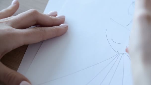 Hand der weiblichen Zeichnung auf Papier in ihrem Atelier. Frauenhand zeichnet einen Bleistift. Designer-Kleidung oder Schneider, Animateur, Künstler oder Illustrator. Künstlerinnen skizzieren mit Bleistift an einem hellen Tag. — Stockvideo