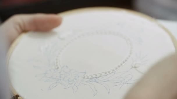 Gros plan de la femme brode une image d'une feuille de fleur sur le tissu. Accueil Artisanat — Video